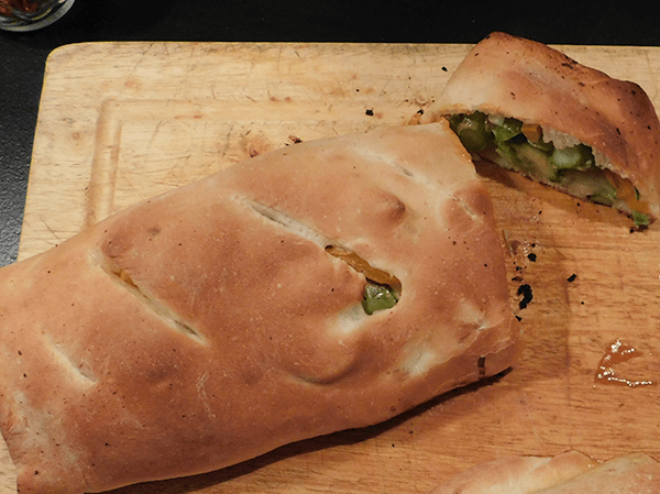 Cooked Calzone cut on chopping board