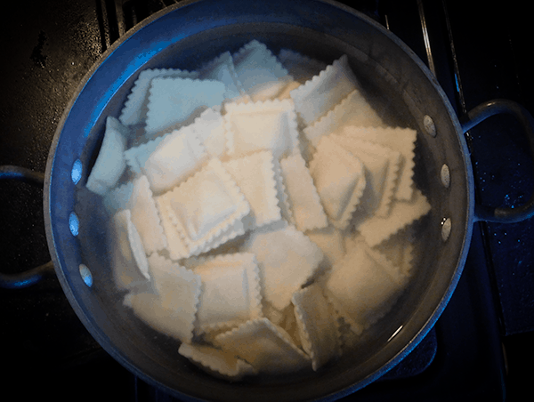 Big pot of water with frozen ravioli in it