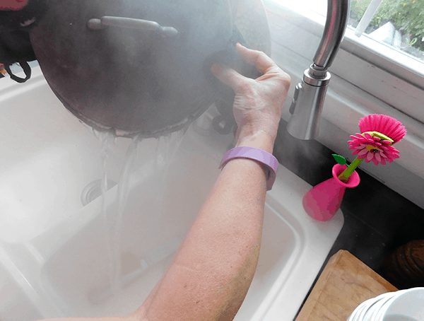 Straining hot water off pasta into sink