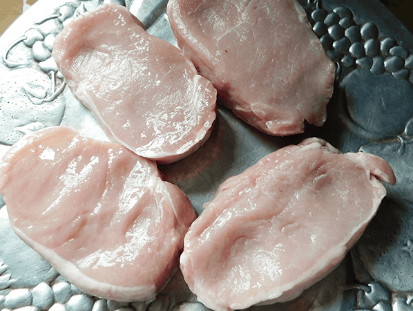 Raw Pork Chops on a silver platter