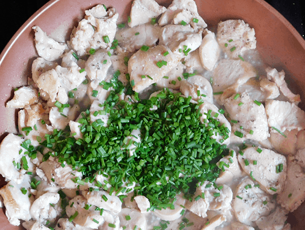 Chicken sautéing in non stick pan with chives