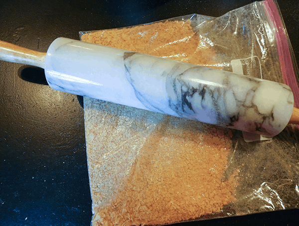 Cornflakes in a plastic bag with a marble rolling pin