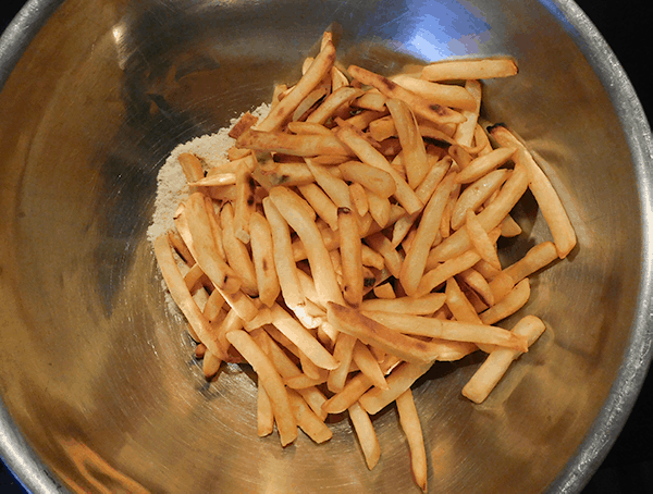 Baked French Fries in a big bowl with spices and cheese