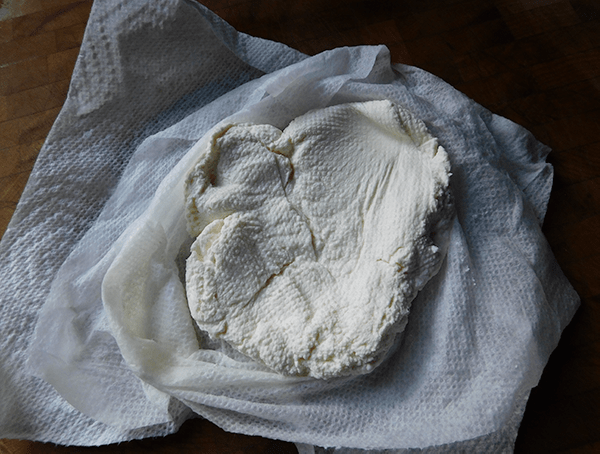 Drained ricotta ready for Ricotta Melon Salad on paper towels