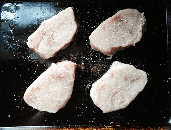 Trimmed boneless pork chops on a baking pan