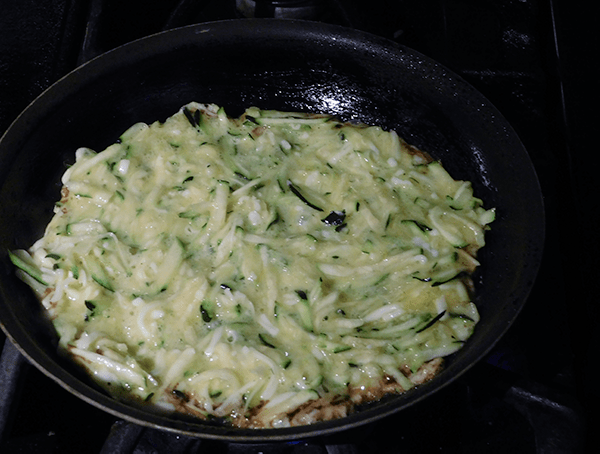 Zucchini Pancakes cooking in a skillet