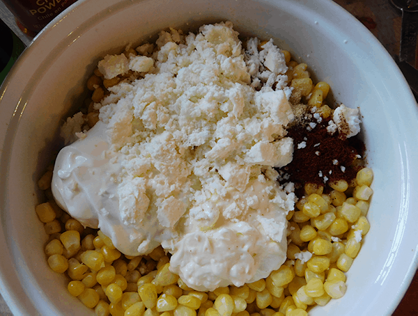 Corn, mayo and queso fresco in a casserole ready to bake into Mexican Street Corn Casserole