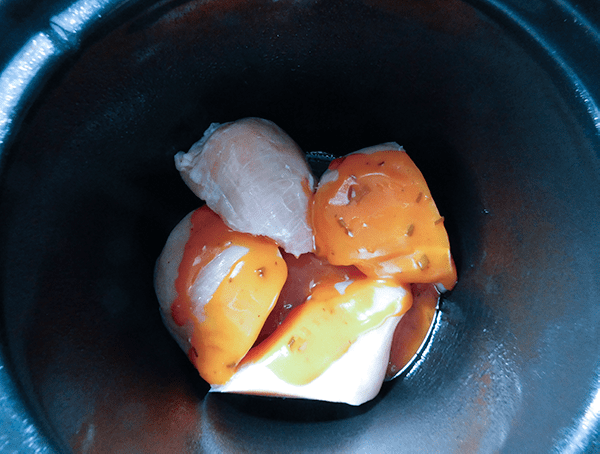 Raw chicken in a slow cooker with French Dressing