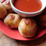 Pepperoni Balls with Sauce on a red plate on a wood block