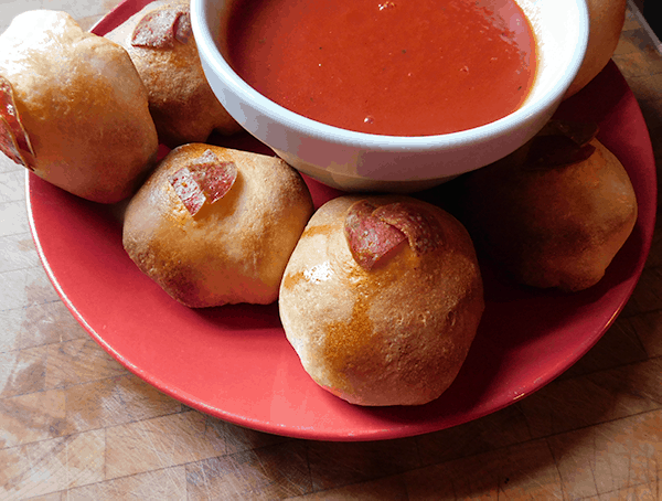 Pepperoni Balls with Sauce on a red plate on a wood block
