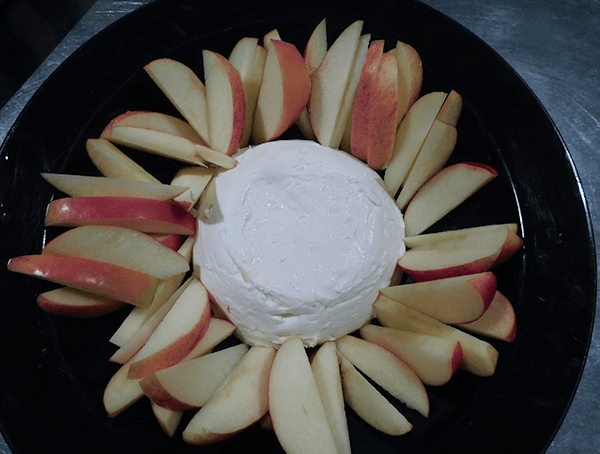 Cream CHeese with apples around it on a black platter