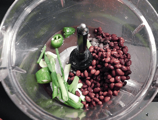 All the ingreidnets for Black Bean Dip in a food processor 