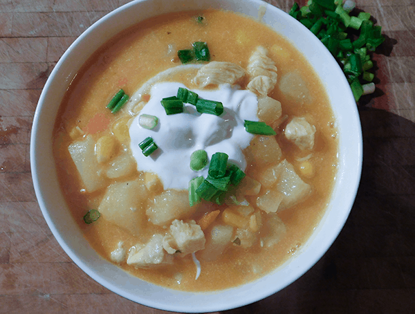 Buffalo Chicken Chowder in a white bowl on a chopping board