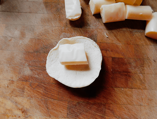 Cheese on a canned biscuit for Cheese Stuffed Garlic Rolls